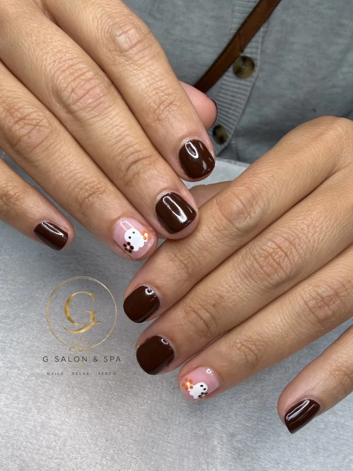 Short brown gel nails with tiny ghost nail art for Halloween at G Salon & Spa in Port St. Lucie, FL