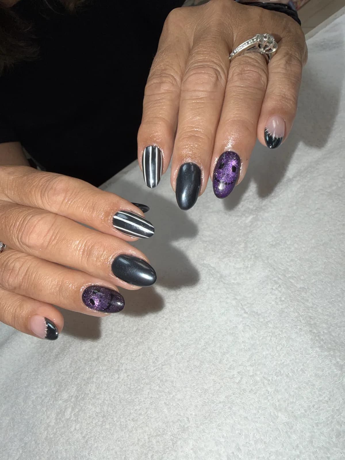 Black and white striped, gunmetal chrome and purple cat-eye Halloween nails at G Salon & Spa in Port St. Lucie, FL
