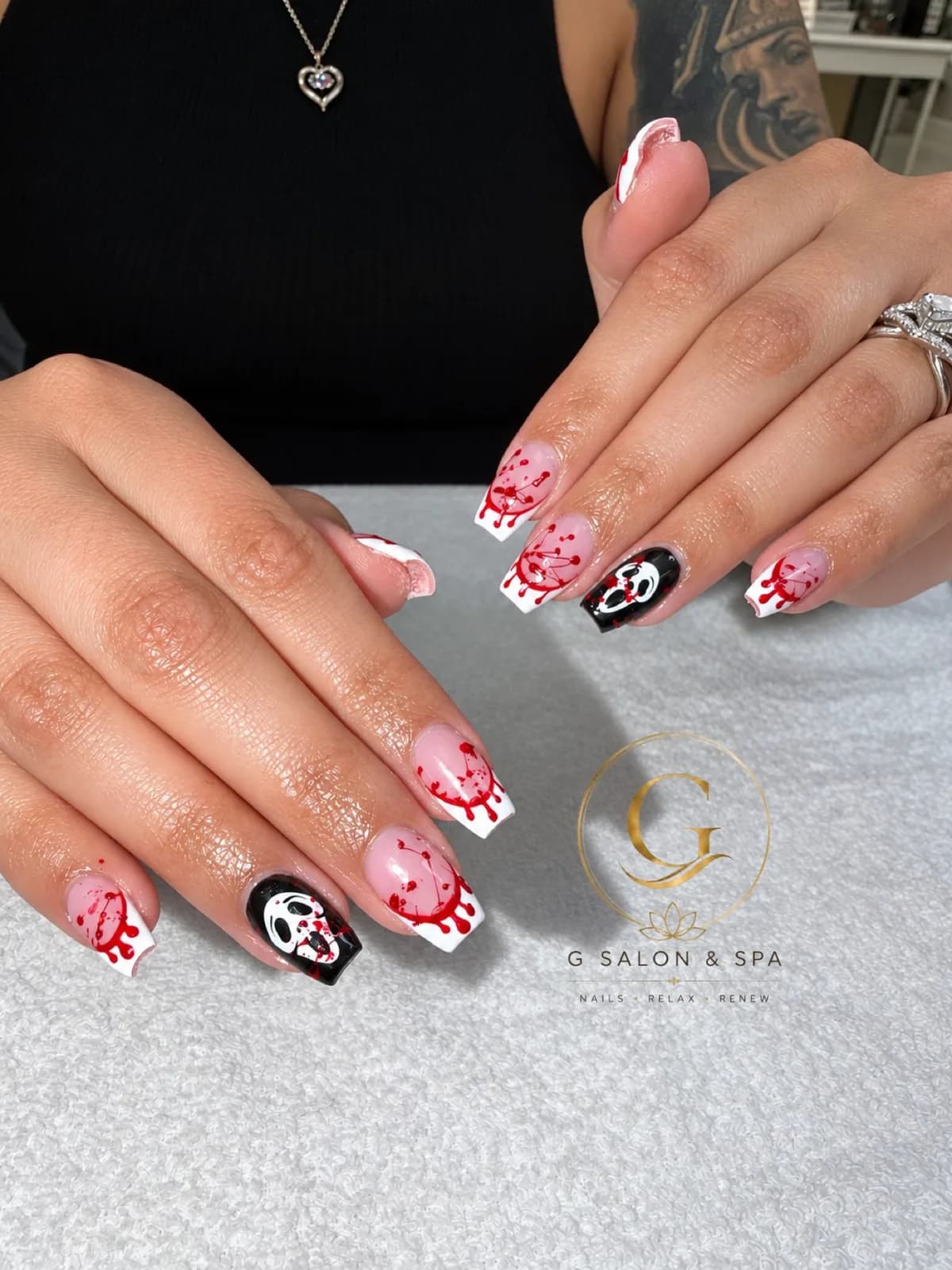 Scream-inspired Ghostface Halloween nails with blood-drip French tips at G Salon & Spa in Port St. Lucie, FL