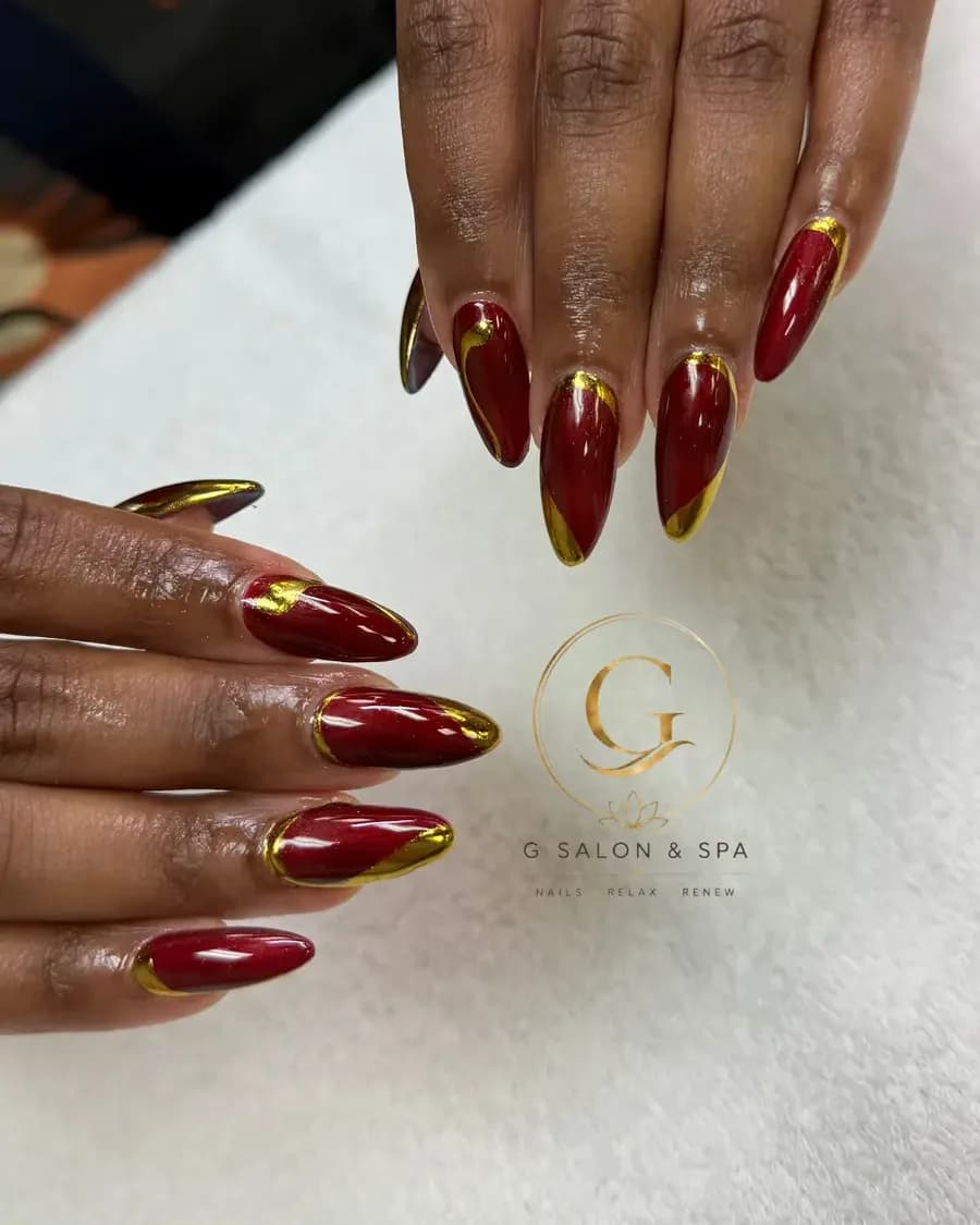 Oxblood red almond nails with gold chrome French edges at G Salon & Spa in Port St. Lucie, FL