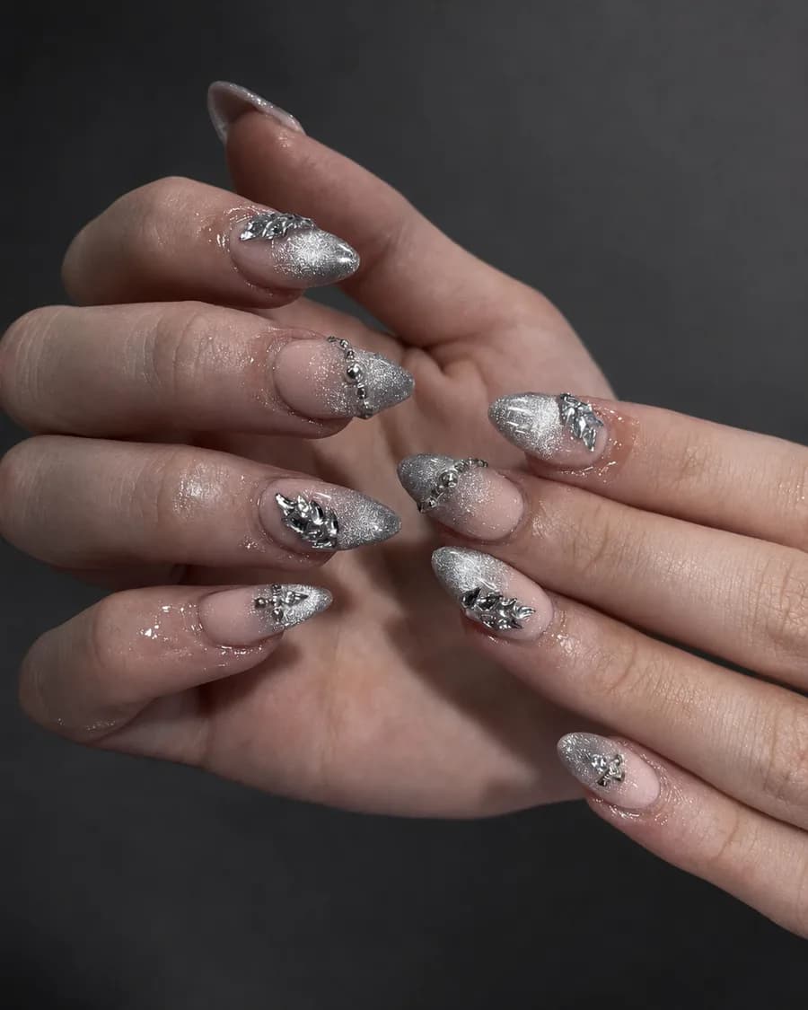 Silver chrome almond nails with silver charms and rhinestones at G Salon & Spa in Port St. Lucie, FL