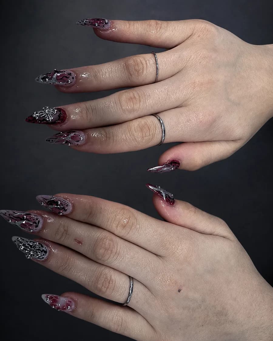Sheer wine stiletto nails with raised silver 3D chrome detail at G Salon & Spa in Port St. Lucie, FL