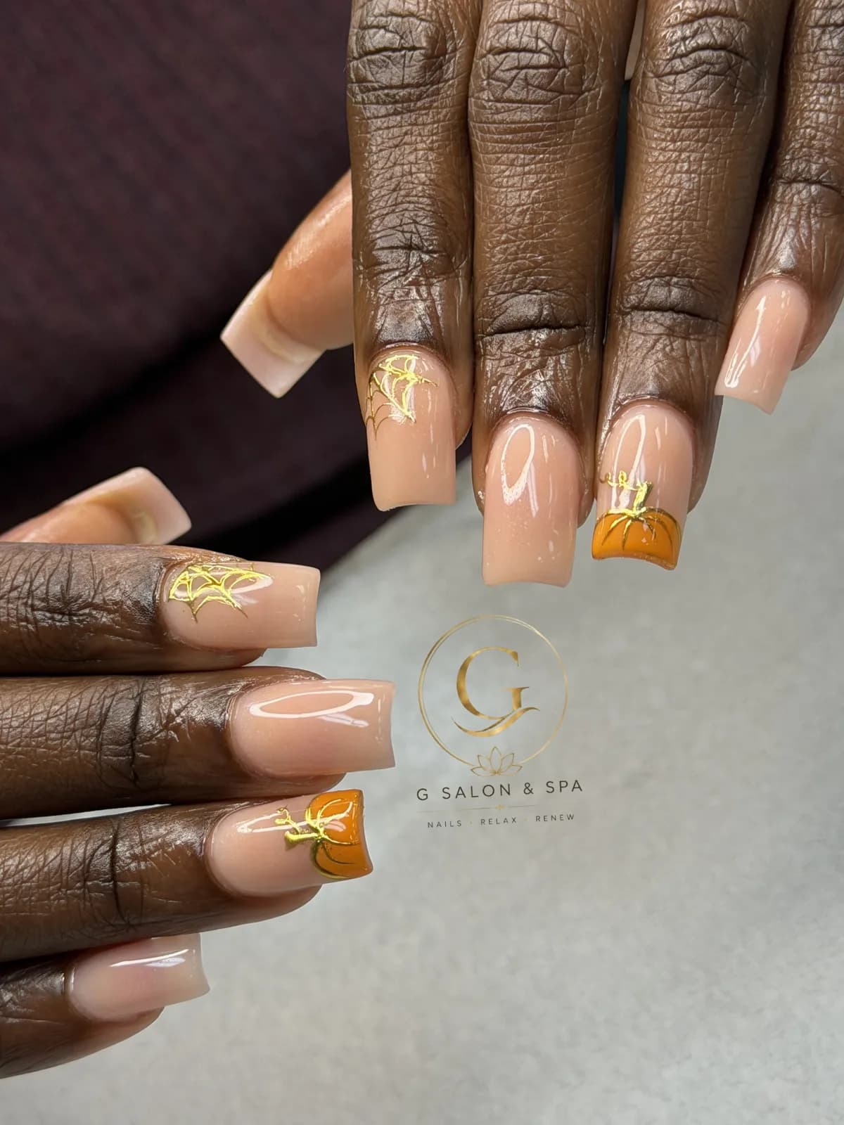 Real Halloween nail set at G Salon & Spa: nude square nails with gold spiderweb foil and orange pumpkin tips