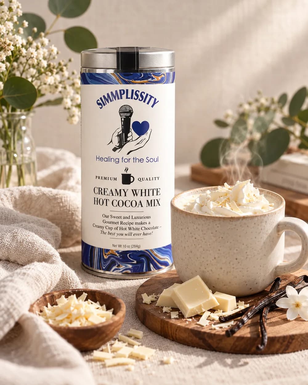 The SIMMPLISSITY Creamy White Hot Cocoa Mix tin styled beside a mug of white hot cocoa