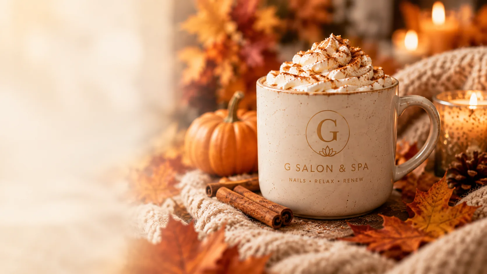 A warm seasonal drink in a G Salon & Spa mug with cinnamon and autumn leaves, in Port St. Lucie, FL