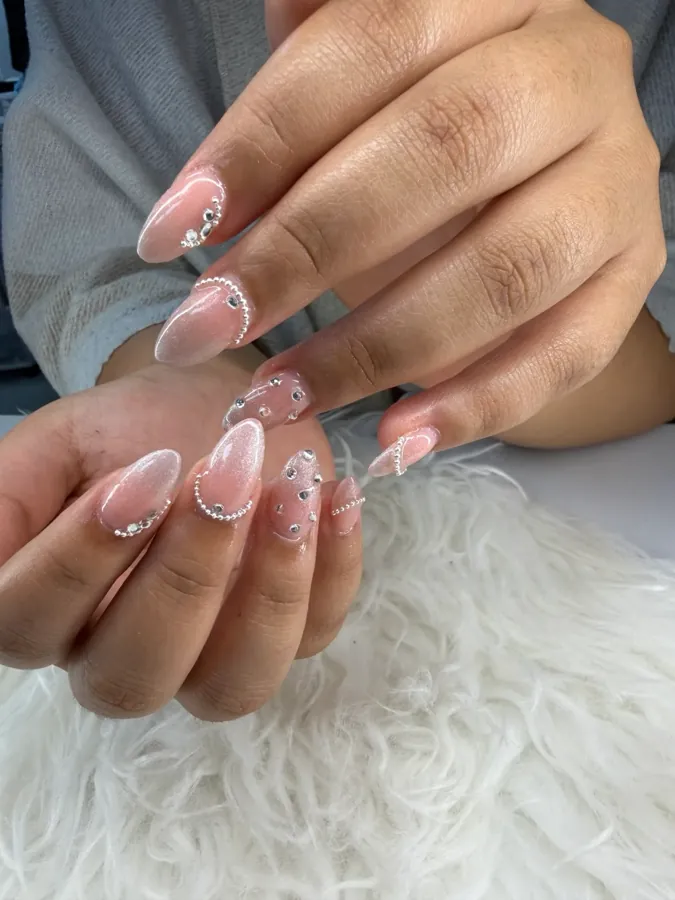 Soft pink almond nails with white French tips and gem accents, done at G Salon & Spa
