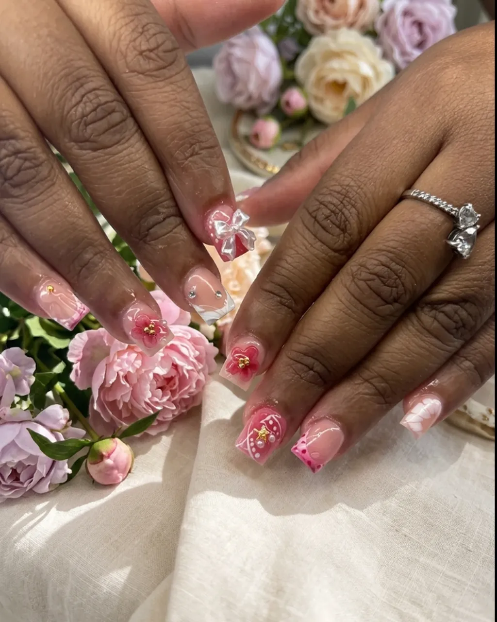 Inspired by a real G Salon set: pink French tip nails with small white bows beside pink peonies