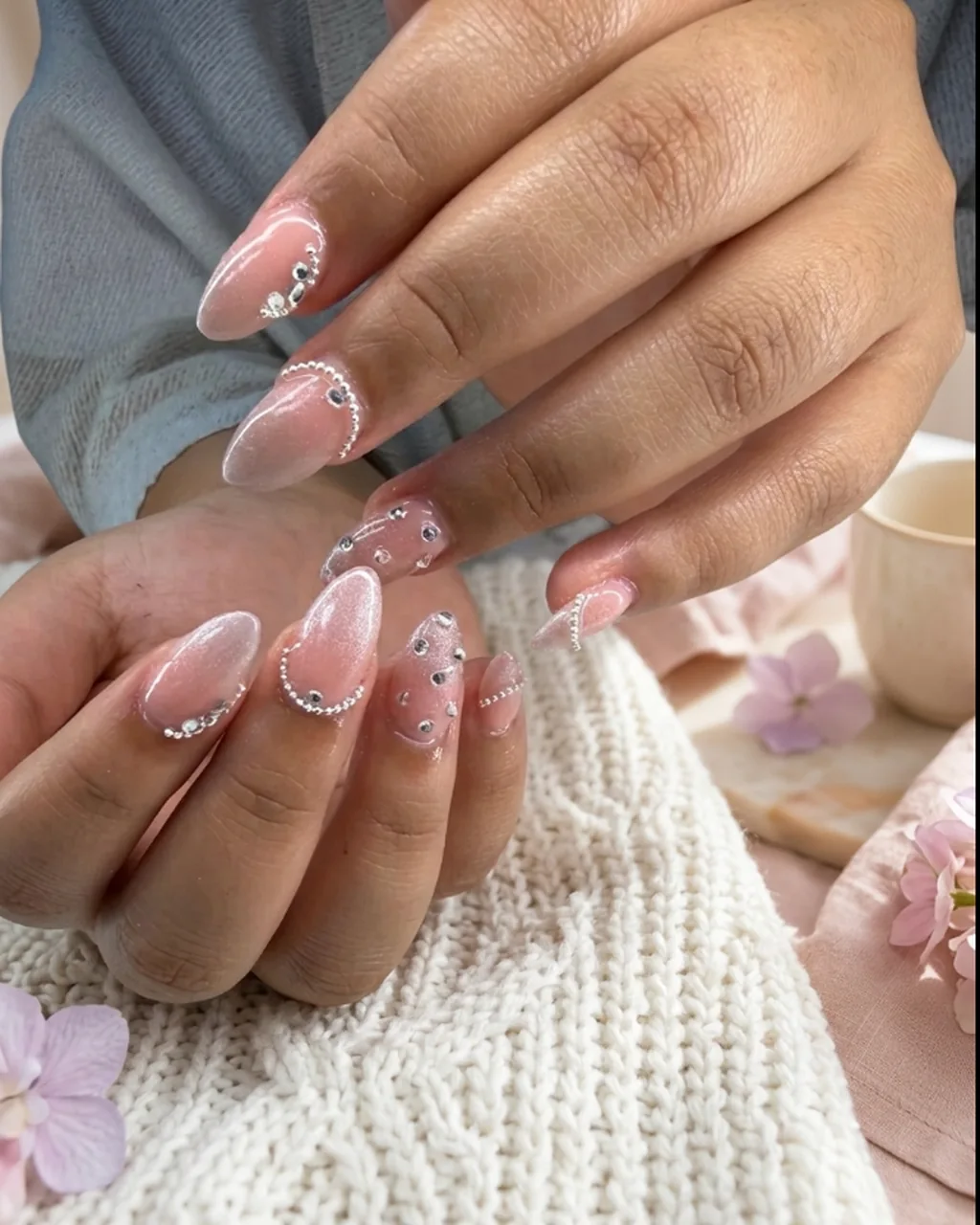 Inspired by a real G Salon set: pearly glazed almond nails with crystal accents on a white knit