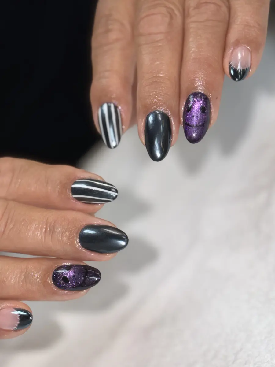 Real Halloween nail set done at G Salon & Spa: gunmetal chrome, black and white stripes and purple cat-eye faces