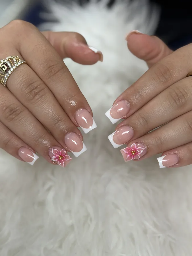 Short French tips with a painted pink flower on two accent nails