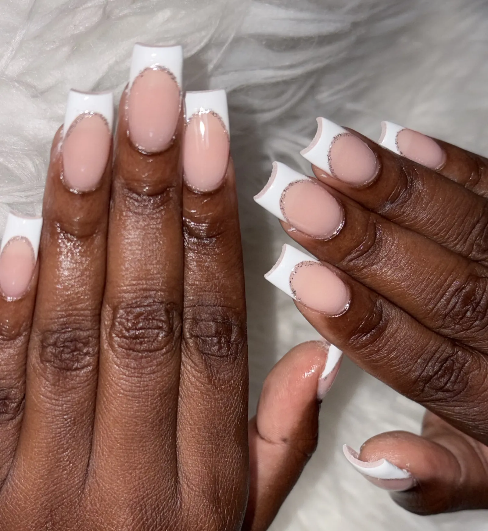 Long square nails with a deep white French tip edged in fine crystals
