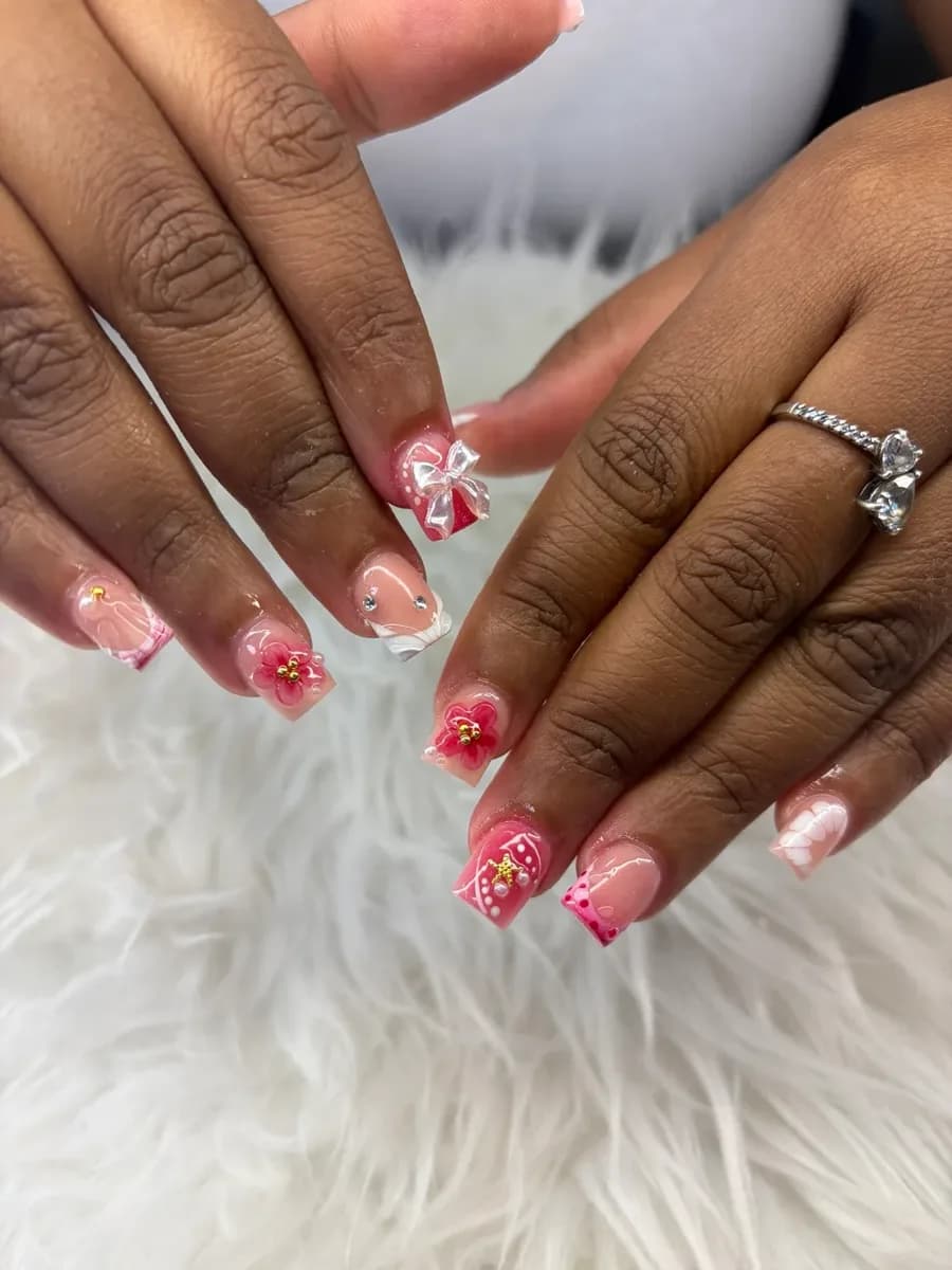 Pink French tip nails with white bows and raised pink flowers, a real set done at G Salon & Spa in Port St. Lucie, FL